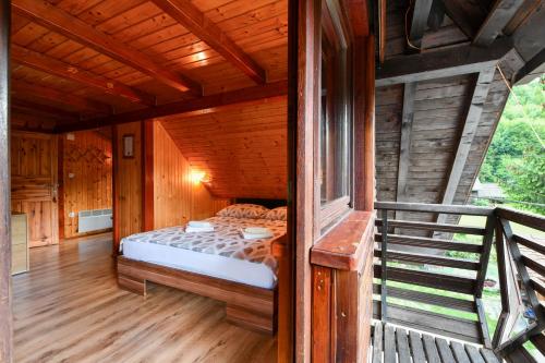 a bedroom with a bed in a wooden house at Guest House Martin in Korana