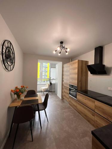 a kitchen and dining room with a table and chairs at Стильна чудова квартира в місті Тернопіль in Ternopilʼ