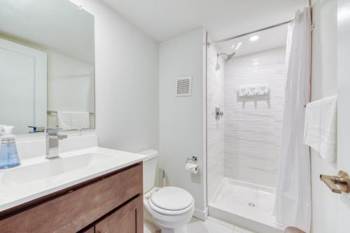 a white bathroom with a shower and a toilet at Sosuite at West Lofts - West Philadelphia in Philadelphia