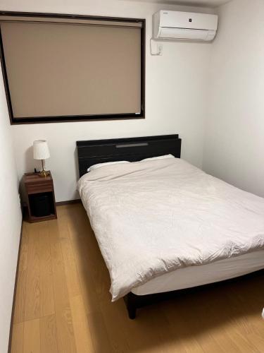1 dormitorio con cama blanca y ventana grande en Guesthouse Hatenashi - Vacation STAY 22571v, en Hongū