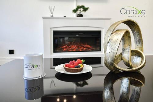 a table with a bowl of fruit and a plate of strawberries at 3 Bedrooms Urban Oasis for Contractors and Families by Coraxe Short Stays in Oldbury