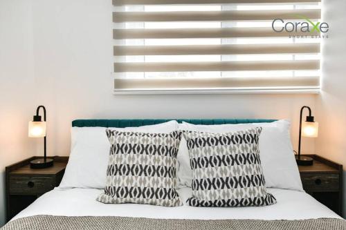 a bedroom with a bed with two pillows and a window at 3 Bedrooms Urban Oasis for Contractors and Families by Coraxe Short Stays in Oldbury