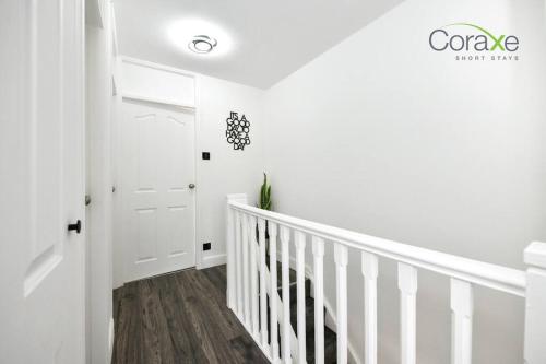 a white staircase in a home with white walls and wood floors at 3 Bedrooms Urban Oasis for Contractors and Families by Coraxe Short Stays in Oldbury