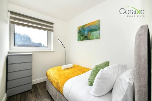 a white bedroom with a bed and a window at 3 Bedrooms Urban Oasis for Contractors and Families by Coraxe Short Stays in Oldbury