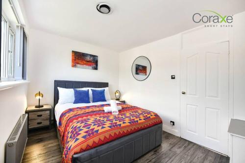 a bedroom with a bed with a colorful blanket at 3 Bedrooms Urban Oasis for Contractors and Families by Coraxe Short Stays in Oldbury