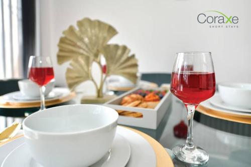 a table with two glasses of red wine and a tray of food at 3 Bedrooms Urban Oasis for Contractors and Families by Coraxe Short Stays in Oldbury