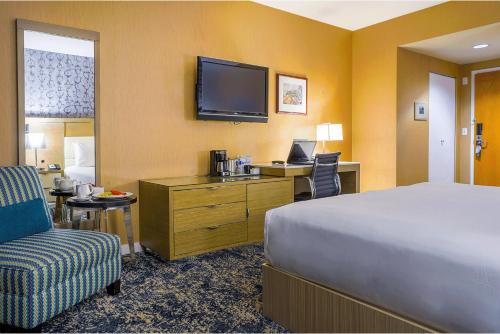 Habitación de hotel con cama, escritorio y TV. en Executive Plaza Hotel & Conference Centre, Metro Vancouver en Coquitlam