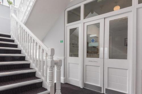 a hallway with a white door and stairs at Plough Hotel in Northampton