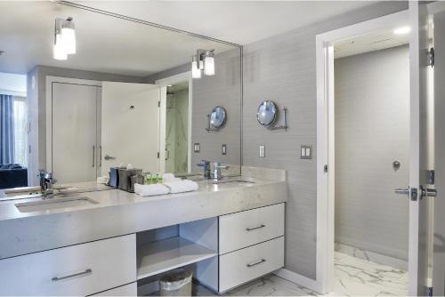 a bathroom with two sinks and a large mirror at Executive Plaza Hotel & Conference Centre, Metro Vancouver in Coquitlam