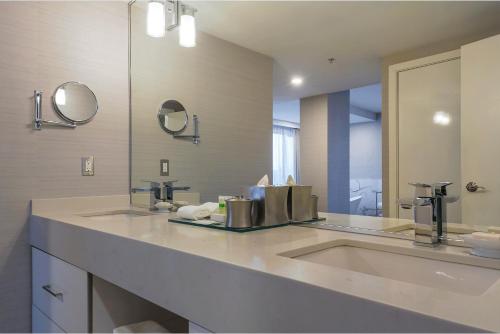 a bathroom with two sinks and a large mirror at Executive Plaza Hotel & Conference Centre, Metro Vancouver in Coquitlam