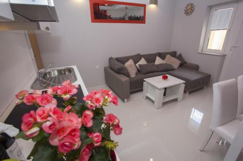 a living room with a couch and a table with flowers at Lara Apartments in Makarska
