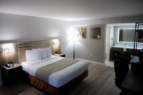 a hotel room with a large bed and a window at Airport Inn in Nederland