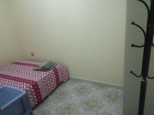 ein kleines Zimmer mit einem Bett und Fliesenboden in der Unterkunft Appart centre in Larache