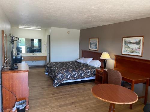 ein Hotelzimmer mit einem Bett und einem Schreibtisch in der Unterkunft Brass Door Motel in Gassville