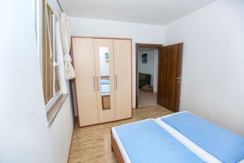 a bedroom with a bed and a door to a room at Ferienhaus Elena, Karlobag in Karlobag