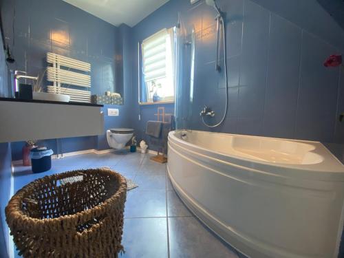 ein Badezimmer mit einer Badewanne, einem Waschbecken und einem WC in der Unterkunft Pool & Lake Holiday Home in Markkleeberg