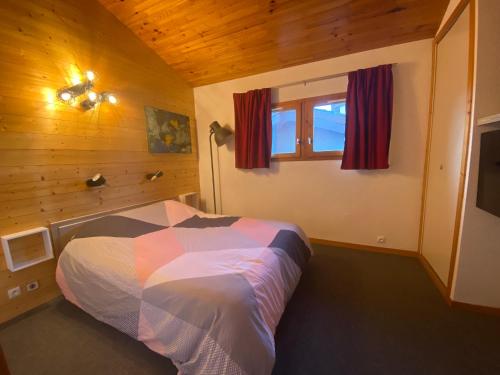 a bedroom with a bed in a wooden room at Appartement duplex 6 couchages 2sdb Parking Ménage inclus in Valmorel