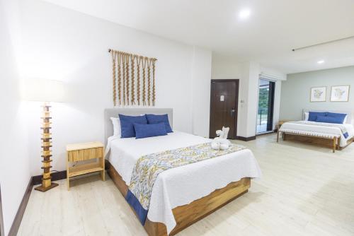 a bedroom with a large bed with blue pillows at Paradise Bay Hotel Boutique in Herradura