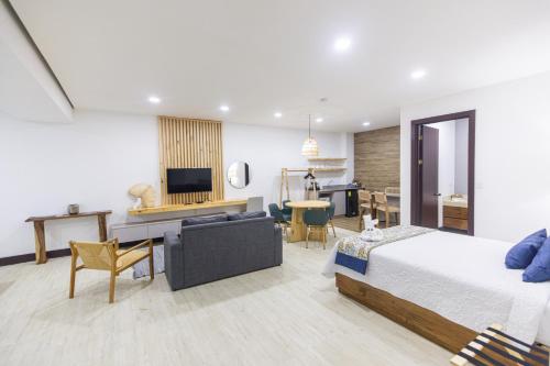 a bedroom with a bed and a living room at Paradise Bay Hotel Boutique in Herradura
