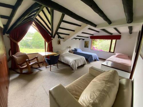 um quarto amplo com 2 camas e um sofá em Naturaleza y calma. Finca a 30 minutos de Bogotá. em Facatativa