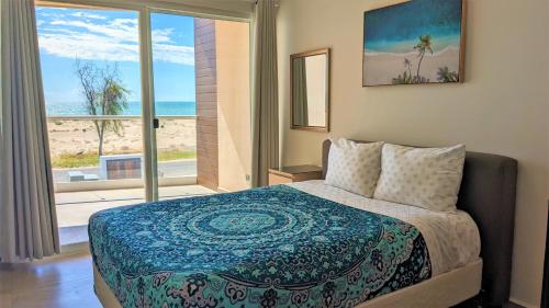 a bedroom with a bed with a view of the beach at Islas Del Mar, Eagle Village B9 in Puerto Peñasco