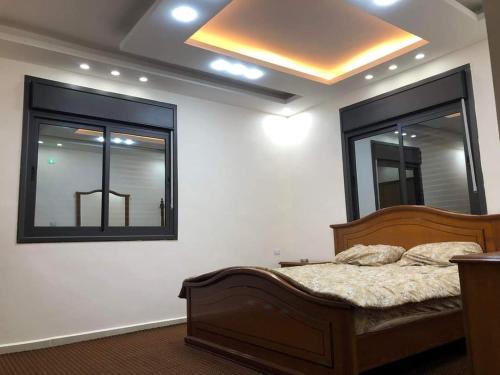 een slaapkamer met een bed en 2 ramen bij Souf house in Jerash