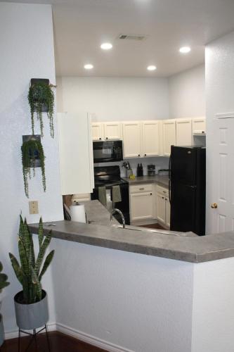 a kitchen with a sink and a black refrigerator at Setting the right vibes. in Killeen