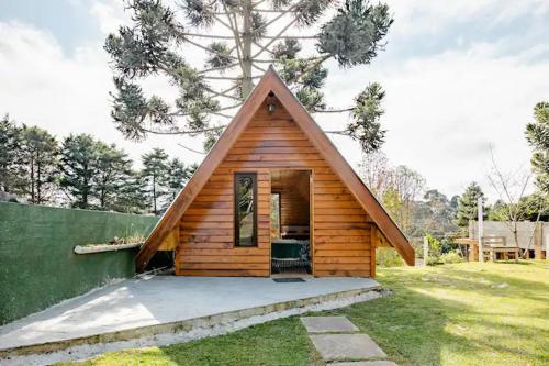 a small wooden cabin with a pitched roof at Chale com hidromassagem Casa Papai Noel in Campos do Jordão