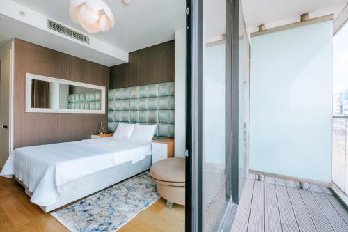 1 dormitorio con 1 cama y puerta corredera de cristal en Cozy Studio Flat w Balcony 10 min to Marmara Forum, en Estambul