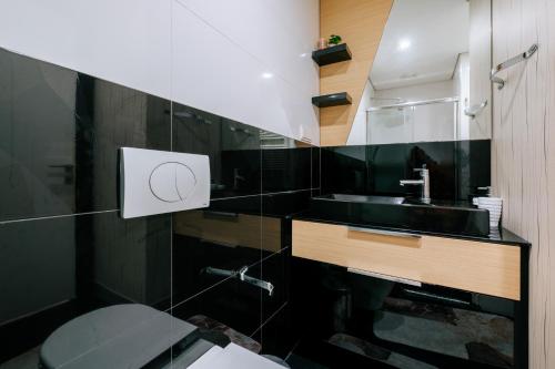 Baño negro con lavabo y aseo en Cozy Studio Flat w Balcony 10 min to Marmara Forum, en Estambul