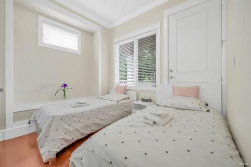 2 łóżka w sypialni z białymi ścianami i oknem w obiekcie Luxurious Getaway in Vancouver-Private room with attached bathroom w mieście Vancouver