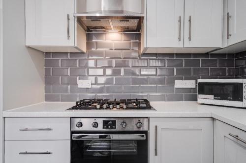 a kitchen with white cabinets and a stove top oven at 17 cliff st. in Liverpool