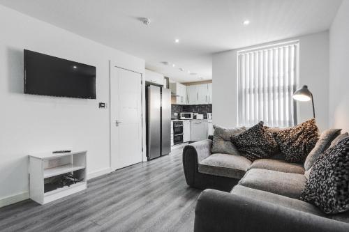 een woonkamer met een bank en een flatscreen-tv bij 17 cliff st. in Liverpool