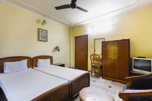 a bedroom with two beds and a tv in it at OYO Flagship Hotel Ajanta in Āsansol