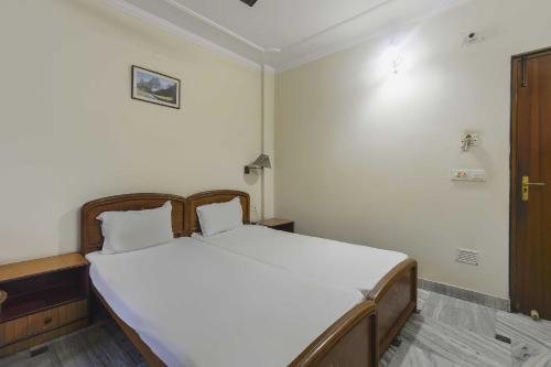 a bedroom with a large bed with white sheets at OYO Flagship Hotel Ajanta in Āsansol