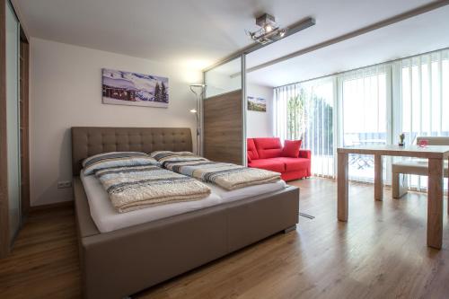 una camera con letto e sedia rossa di Alpine Appart a Bad Hofgastein