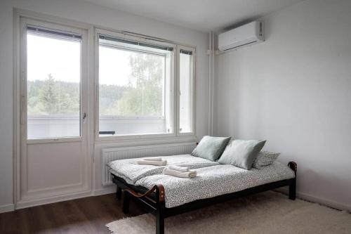 a white room with a bed in front of a window at Moderni ja tilava kolmio + sauna in Kuopio