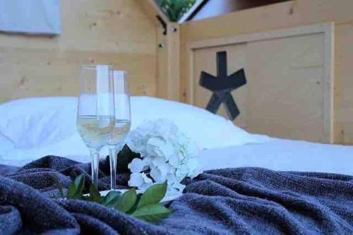 un paio di bicchieri da vino seduti su un letto di Starsbox con piscina e idromassaggio a Celle Ligure
