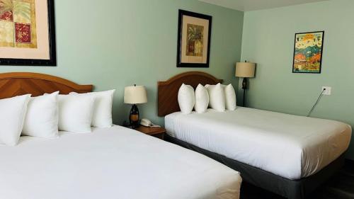 2 bedden in een hotelkamer met witte kussens bij Adventure Inn - Glenwood Springs in Glenwood Springs