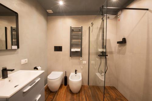 a bathroom with a toilet and a sink and a shower at San Benedetto Rooms in Crema