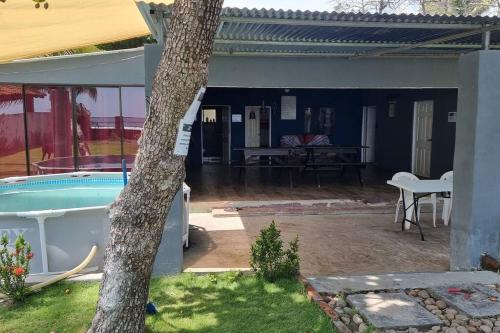 un patio trasero con una piscina y un árbol en Hermosa Casa de Playa DejaBlue SV (con Mini Golf), en La Libertad