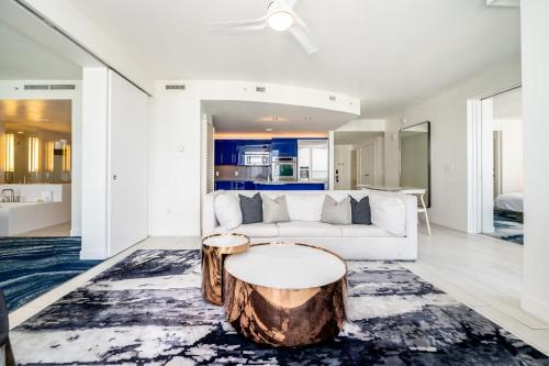 a living room with a white couch and a tree stump coffee table at Beachfront Luxury 2BR 2BA, Sleeps 6, Resort Access - Horizon by HomeStakes in Fort Lauderdale