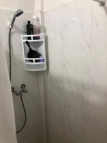 un chat noir assis sur une étagère dans une salle de bains dans l'établissement Vittel Ifrane Large and Beautiful Apartment, à Ifrane