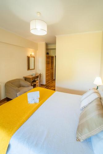 a bedroom with a large bed with a yellow blanket at Casa da Tia Clementina in Santana
