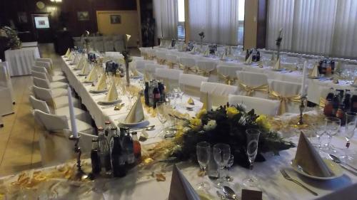 a table set up for a wedding with white tables and chairs at ABC Hotel Nitra in Nitra