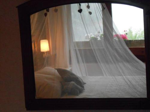 a picture of a bed with a canopy and a window at Masia Can Constans in Queralbs