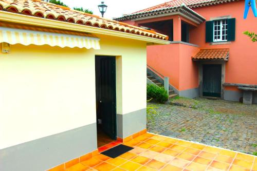 a red and white house with a black door at Casa da Tia Clementina in Santana