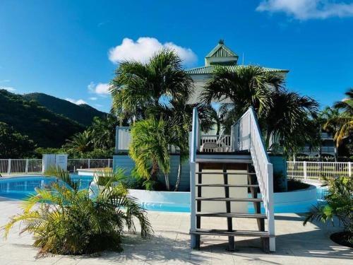 a white staircase in front of a swimming pool at Le Palmier Bleu, cocon tropical, plage & piscine in Anse Marcel 