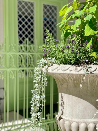 a stone planter with flowers in front of a green building at Villa Wickenburg in Salzburg