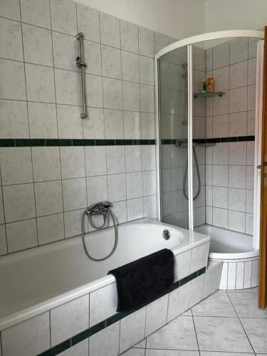 a bathroom with a bath tub and a shower at Ferienwohnung Nahe Schiffshebewerk 